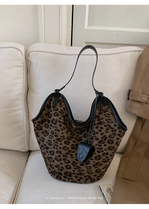 Gros plan du sac cabas en suédine imprimé léopard avec fines anses en cuir noir chic