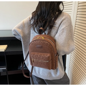 Detailed back view of a plush leopard print backpack with adjustable shoulder straps and top handle