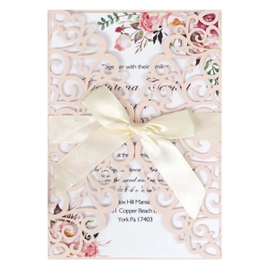 Laser cut pink wedding invitation set with elegant lace patterns and a satin ribbon bow