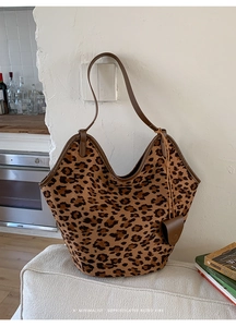 Détail du cabas en daim léopard avec anses en cuir marron dans un décor de maison rétro