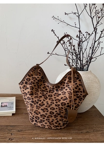 Gros plan du sac hobo léopard avec bordures en cuir marron et pochette décorative
