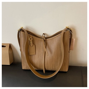 Dettaglio borsa tote marrone intrecciata con trama verticale e finiture dorate