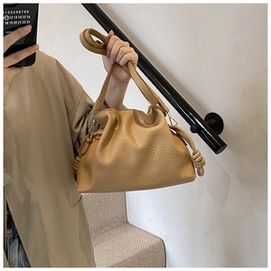 Detailed view of khaki lychee grain leather bucket bag with soft drawstring fold design