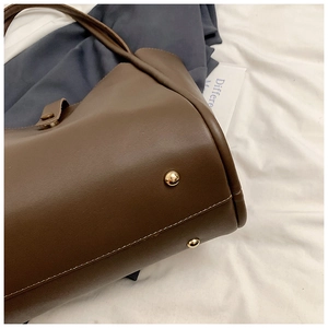 Vue détaillée du fond du sac en cuir marron avec rivets de protection en métal doré