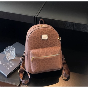 Macro shot of brown leopard print backpack with matte texture and gold zipper detail