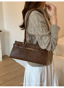 Close-up of a brown vintage shoulder bag featuring a gold twist lock and fine PU texture