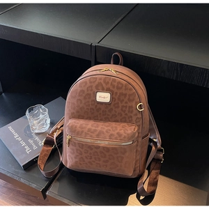 Close-up of leopard print backpack showing brown suede texture and golden zipper detail