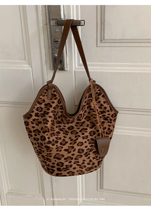 Détail du sac cabas rétro à imprimé léopard en daim avec lanières en cuir et coutures soignées