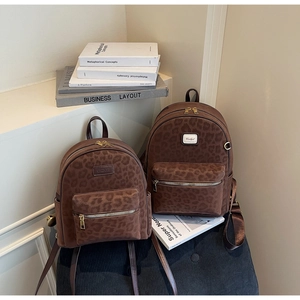 Detailed view of leopard print backpacks in two sizes with gold zippers and metal hardware