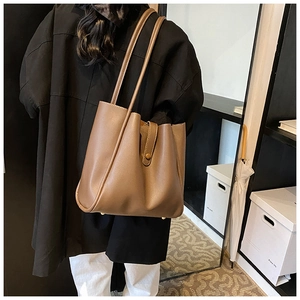 Vue détaillée du sac cabas marron en cuir avec bouton pression et grand espace interne