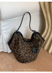 Gros plan du cabas en daim léopard avec anses en cuir noir et breloque petit sac assorti