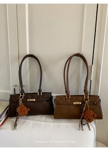 Detail view of vintage Boston bags in dark coffee and brown with cute bear charms