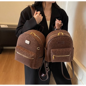 Close-up of leopard print travel backpacks with gold zippers and premium matte texture