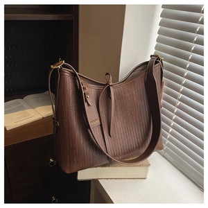 Dettaglio borsa hobo in pelle intrecciata marrone scuro con tracolla larga e fibbia oro