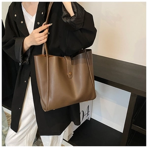 Vue détaillée du grand sac cabas en cuir marron foncé avec fermeture à sangle et intérieur