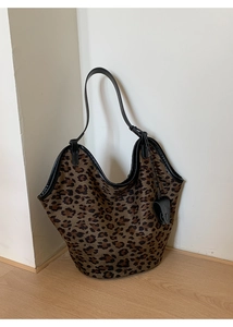 Détail de sac cabas vintage à motif léopard avec des anses en cuir noir de qualité