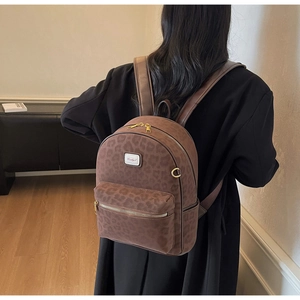 Detail view of leopard print backpack with gold zippers and premium suede texture