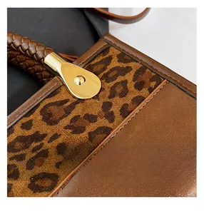 Détail du sac à main en cuir marron avec imprimé léopard et boucles dorées