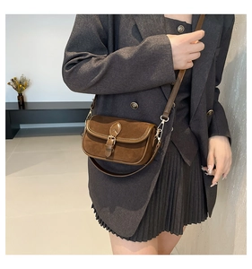 Detail of vintage brown square bag with metal buckle on a neutral blazer outfit