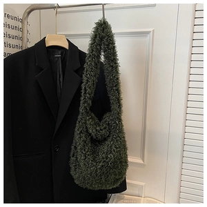 Detail of soft olive green faux fur tote bag hanging next to a formal black blazer
