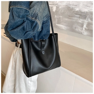 Gros plan d'un sac cabas noir mat avec sangle à boucle fonctionnelle et bouton pression