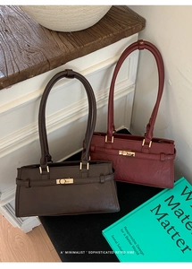 Detail of dark brown and wine red vintage shoulder bags with gold metal clasps and long handles
