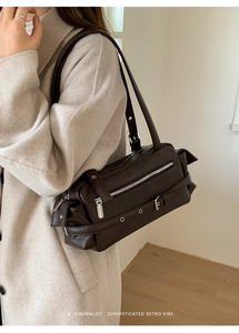 Detail of vintage brown leather shoulder bag with buckle straps and silver eyelets