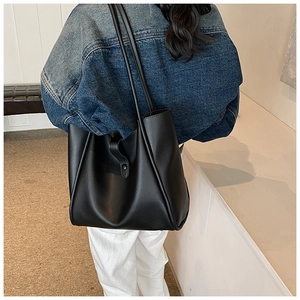 Détail d'un grand sac cabas noir minimaliste avec fines lanières et boucle en métal