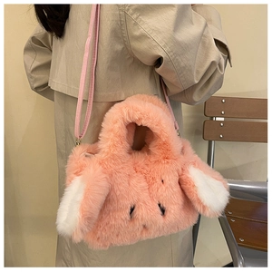 Detail of pink plush bunny shoulder bag with white ears worn on a beige trench coat
