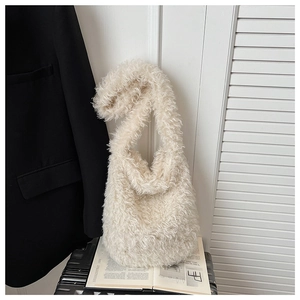 Detail shot of plush cream faux fur texture on a soft shoulder bag in a stylish setting