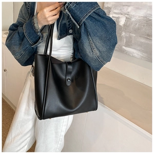 Détail d'un grand sac fourre-tout noir en similicuir avec boucle et fines bandoulières