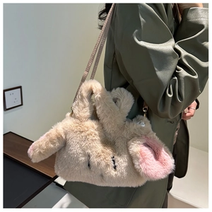 Detail view of the plush bunny handbag texture and shoulder strap on a green coat