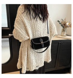 Retro black faux suede crossbody bag with gold buckle styled with a white knit sweater