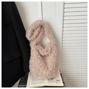Detail of soft beige faux shearling tote bag on a magazine in a modern setting