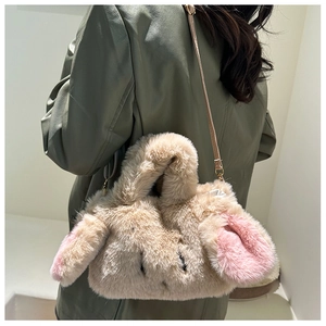 Detail of cute plush bunny crossbody bag with soft pink ears and gold chain strap