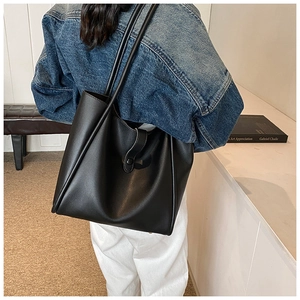 Vue détaillée du grand sac cabas noir avec longues anses et fermeture à bouton-pression
