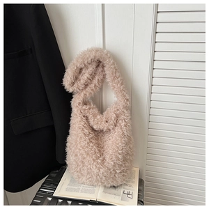 Macro detail of plush faux fur texture and soft handle on this pink shoulder tote bag