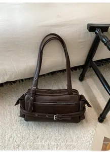 Detailed view of chocolate brown rectangular shoulder bag with vintage metal buckle and zippers