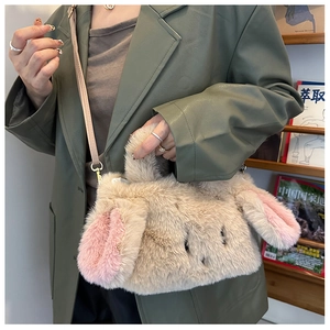 Close-up of fluffy rabbit ear plush bag with metal rings and beige leather strap detail