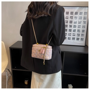 Dettaglio della mini borsa a scatola in tweed rosa con doppia zip e catena dorata