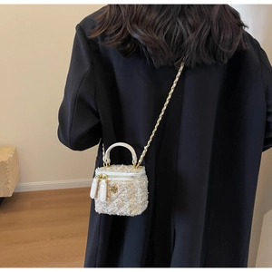 Crossbody view of white tweed mini vanity bag with gold chain and camellia hardware