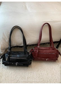 Detail of vintage tote bags in black and burgundy with metallic buckles and side straps