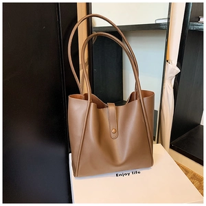 Détail du grand sac cabas en simili cuir marron avec fines bretelles et fermeture à bouton