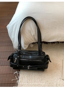 Close-up of retro black Boston shoulder bag with silver zippers and punk metal eyelets