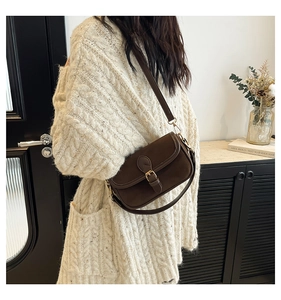 Retro dark brown matte suede crossbody bag styled with beige knit sweater in a cozy setting