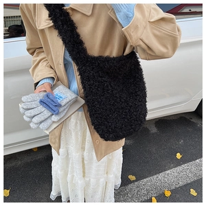 Detail of black faux shearling crossbody tote bag with soft plush texture for winter style