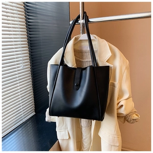 Détail du grand sac cabas noir avec doubles bandoulières et fermeture à bouton pression