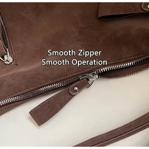 Close-up of smooth metal zipper on vintage dark brown leather tote bag detail