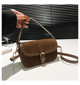 Detail of vintage brown crossbody bag with suede stitching and golden metal buckle