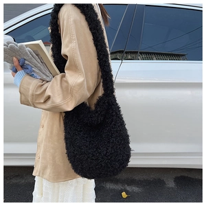 Detail of black faux shearling tote bag showing texture and large capacity fit